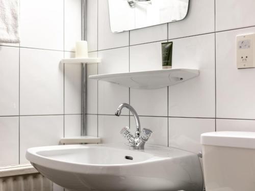 a white bathroom with a sink and a mirror at Brixen Alpin Living Top 16 in Brixen im Thale