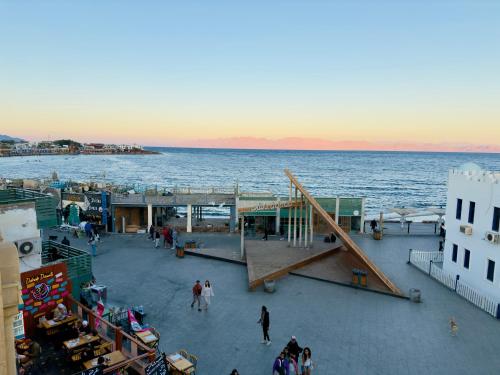 un grupo de personas caminando en un muelle junto al agua en Every Day Hotel, en Dahab