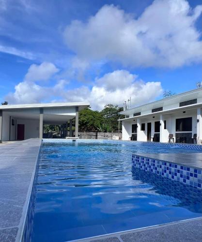 a swimming pool in front of a building at Viva La Rosa Hometel in Anda