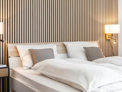 a bedroom with two white beds and a striped wall at Brixen Alpin Living Top Alle in Brixen im Thale
