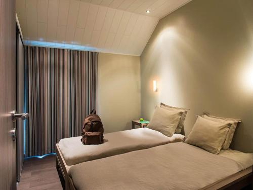 a room with two beds with a backpack sitting on them at Serene Luxe Lakeside Stay in Boussu-lez-Walcourt