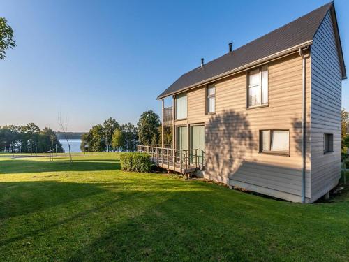 a house with a large yard next to a lake at Serene Luxe Lakeside Stay in Boussu-lez-Walcourt
