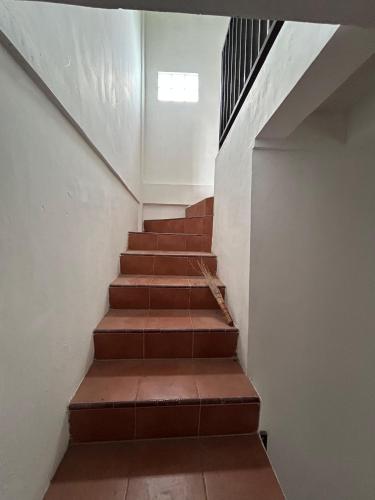 a stairway with brown steps and a window at Plamo Residence G5 in Batam Center