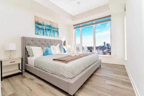 a bedroom with a bed and a large window at High Rise 1BR Building w Gorgeous Views in Kitchener