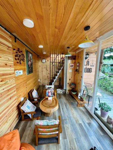 a living room of a cabin with a wooden ceiling at HomeTa Homestay in Bao Loc