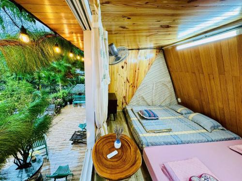 a small room with a bed and a table at HomeTa Homestay in Bao Loc