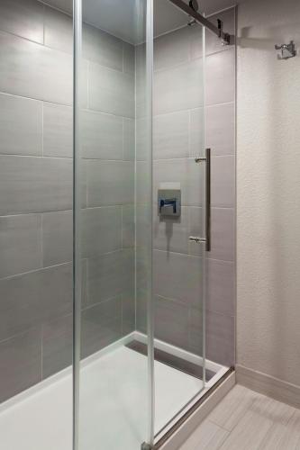 a shower with a glass door in a bathroom at Marriott Jacksonville in Jacksonville