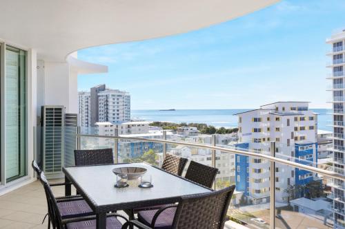 a balcony with a table and chairs and a view of the ocean at Aqua Vista Resort in Maroochydore
