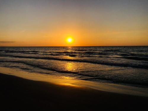 a sunset on the beach with the ocean at Eco Hotel Laguna Beach - Bloque 8 Suite 101 in San Silvestre