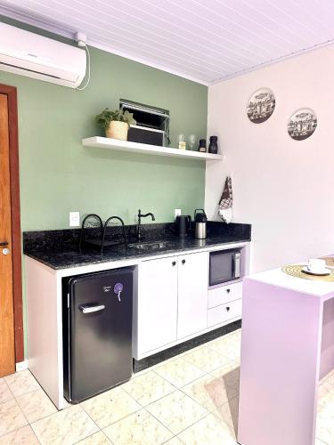 a kitchen with a black and white stove top oven at La Vita studio Lavanda in Nova Veneza
