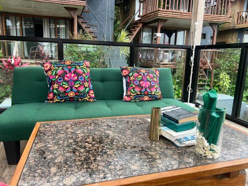 a green couch on a patio with a table at Bintana sa Paraiso Binunsaran in Mambajao