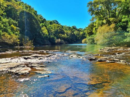 a river with rocks and trees in the background at Cabañas complejo Ysyry Misiones in Puerto Victoria