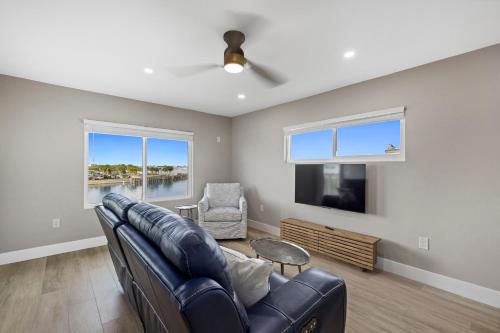 a living room with a leather couch and a tv at Chadwick Cove Marina in Englewood