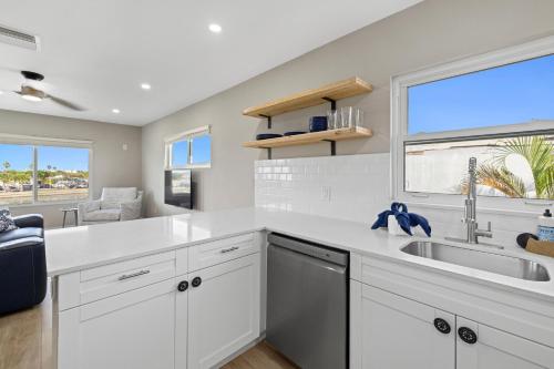 a kitchen with white cabinets and a sink and a window at Chadwick Cove Marina in Englewood