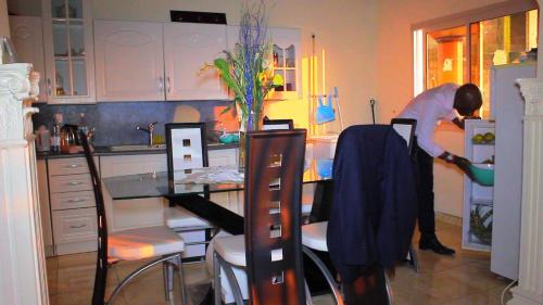 a woman standing in a kitchen with a table at Résidence Hotelière Borel Denver in Douala