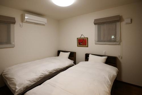 two beds sitting next to each other in a bedroom at Villa Fuji-nishiki in Fujikawaguchiko