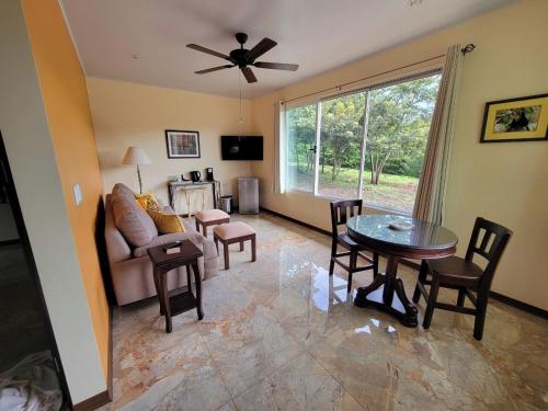 a living room with a table and a couch at 2 Bedroom Guest House with Pool in Hacienda Miravalles