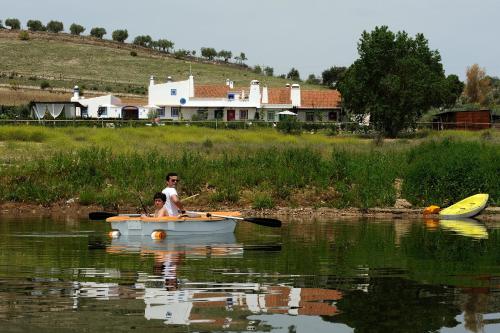 a man and a boy in a boat on the water at Casas de Juromenha in Juromenha