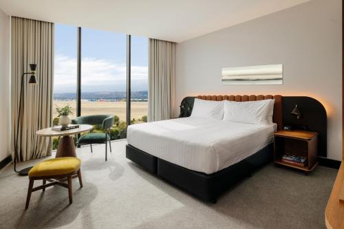 a hotel room with a bed and a large window at Crowne Plaza Adelaide Mawson Lakes by IHG in Adelaide