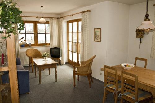 a living room with a table and a dining room at Appartements Alpenresidenz in Weitnau