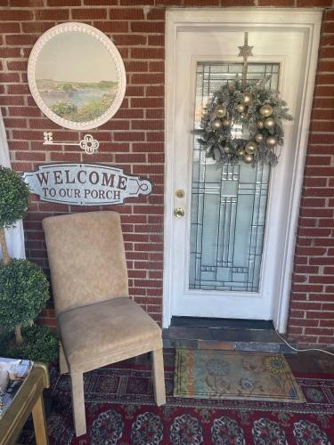 a welcome to our porch door with a chair and a wreath at Cozy room near Airport & Highway in Saint Louis