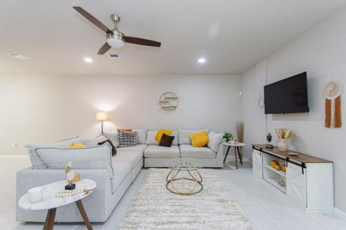 a living room with a couch and a flat screen tv at 3BR 2 & half Bath Townhouse Modern Spacious Retreat Near Lake Conroe! in Conroe