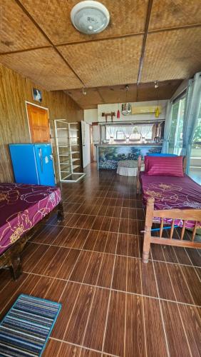 a room with two beds and a wooden floor at Baan Suan Resort Doisaket 1 in Ban Tha