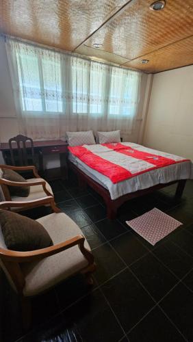 a bedroom with a large bed and two chairs at Baan Suan Resort Doisaket 1 in Ban Tha