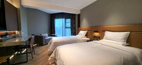 a hotel room with two beds and a desk at Shengjing Hotel Beijing Temple of Heaven East Gate Subway Station Branch in Beijing