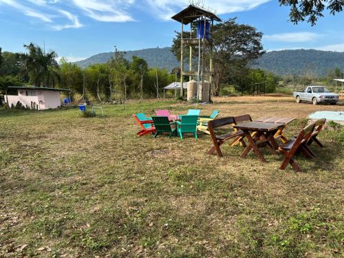 a group of chairs and a picnic table in a field at ฟาร์มผัก Thank you in Ban Kom