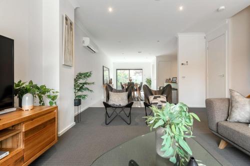 a living room with a couch and a tv at VAQUAY Contempo In Flemington in Melbourne