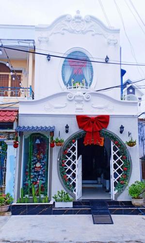 ein weißes Haus mit Weihnachtsdekoration darauf in der Unterkunft Hoàng Nga 1 Homestay in Phan Thiet