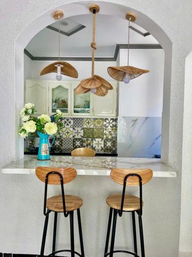 eine Küche mit zwei Barhockern an der Theke in der Unterkunft Hoàng Nga 1 Homestay in Phan Thiet