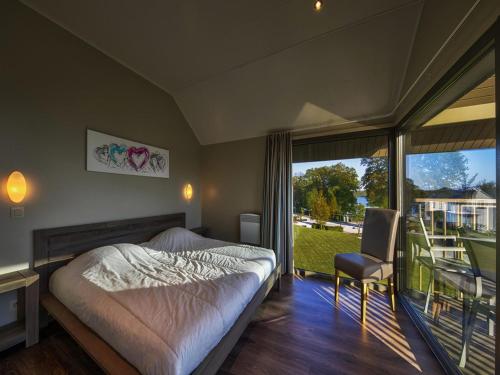 a bedroom with a bed and a large window at Tranquil Villa for 8 Guests in Boussu-lez-Walcourt