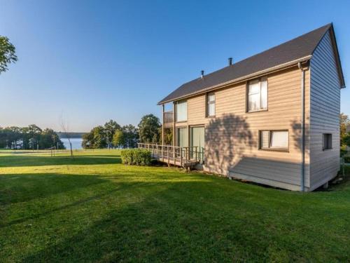 a house with a large yard next to a lake at Tranquil Villa for 8 Guests in Boussu-lez-Walcourt