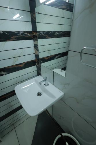 a bathroom with a white sink and a mirror at Kailasam Residency in Trivandrum