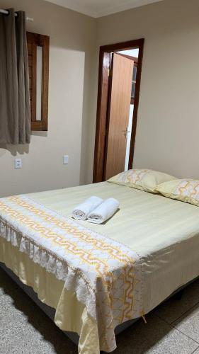 a bed in a room with two pillows on it at Pousada Maria Moura in Camacari