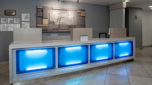 a row of blue fish tanks in a room at Holiday Inn Express Mexico Santa Fe by IHG in Mexico City
