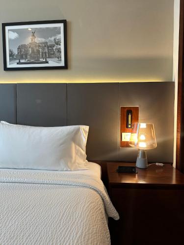 a bedroom with a bed and a lamp on a table at Holiday Inn Santo Domingo by IHG in Santo Domingo