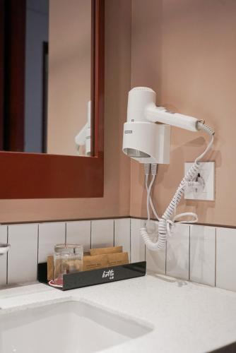 a bathroom with a blow dryer on a sink at Kotta GO Hotel Tegal in Tegal