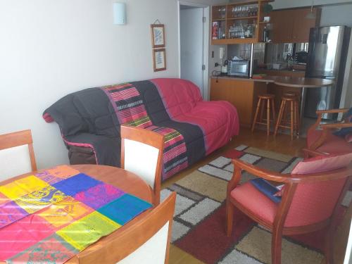 un salon avec un canapé et une cuisine dans l'établissement Departamento La Serena 4 personas, à La Serena