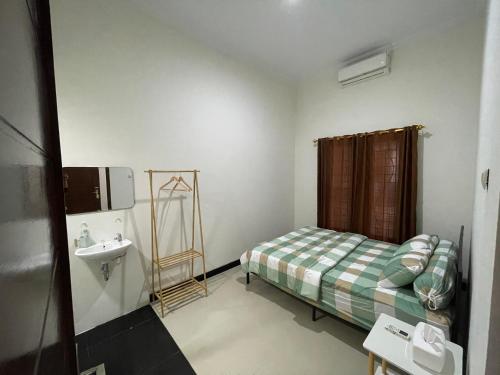 a small bedroom with a bed and a sink at Rdk Homestay in Jarakan