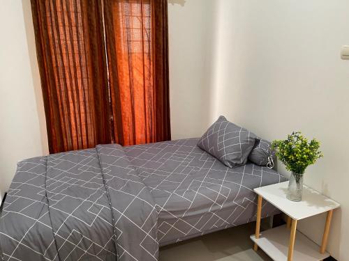 a bed with a gray comforter in a bedroom at Rdk Homestay in Jarakan