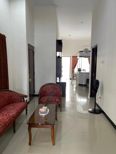 a living room with two red couches and a coffee table at Rdk Homestay in Jarakan