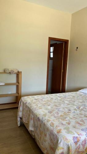 a bedroom with a bed and a open door at Pousada Maria Moura in Camacari