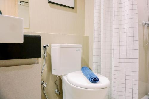 a bathroom with a toilet with a blue pillow on it at Homey and Simply Look 1BR Bintaro Embarcadero Apartment By Travelio in Tangerang