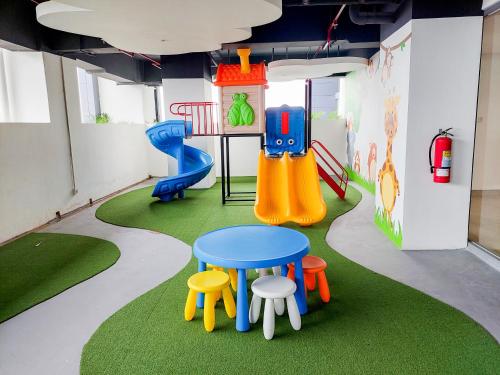 a play room with a table and a slide at Homey and Simply Look 1BR Bintaro Embarcadero Apartment By Travelio in Tangerang