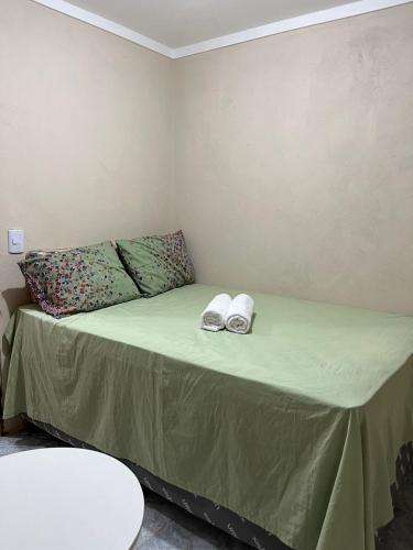 a bed in a room with two shoes on it at Pousada Maria Moura in Camacari