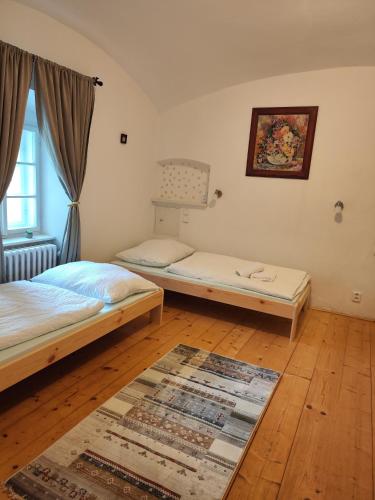 a bedroom with two beds and a rug on the floor at Statek Napořád in Předslavice