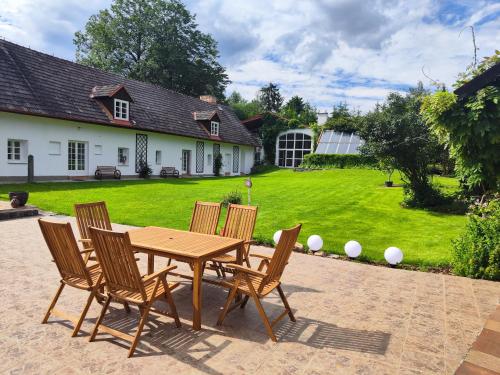 a wooden table with four chairs and a yard at Statek Napořád in Předslavice
